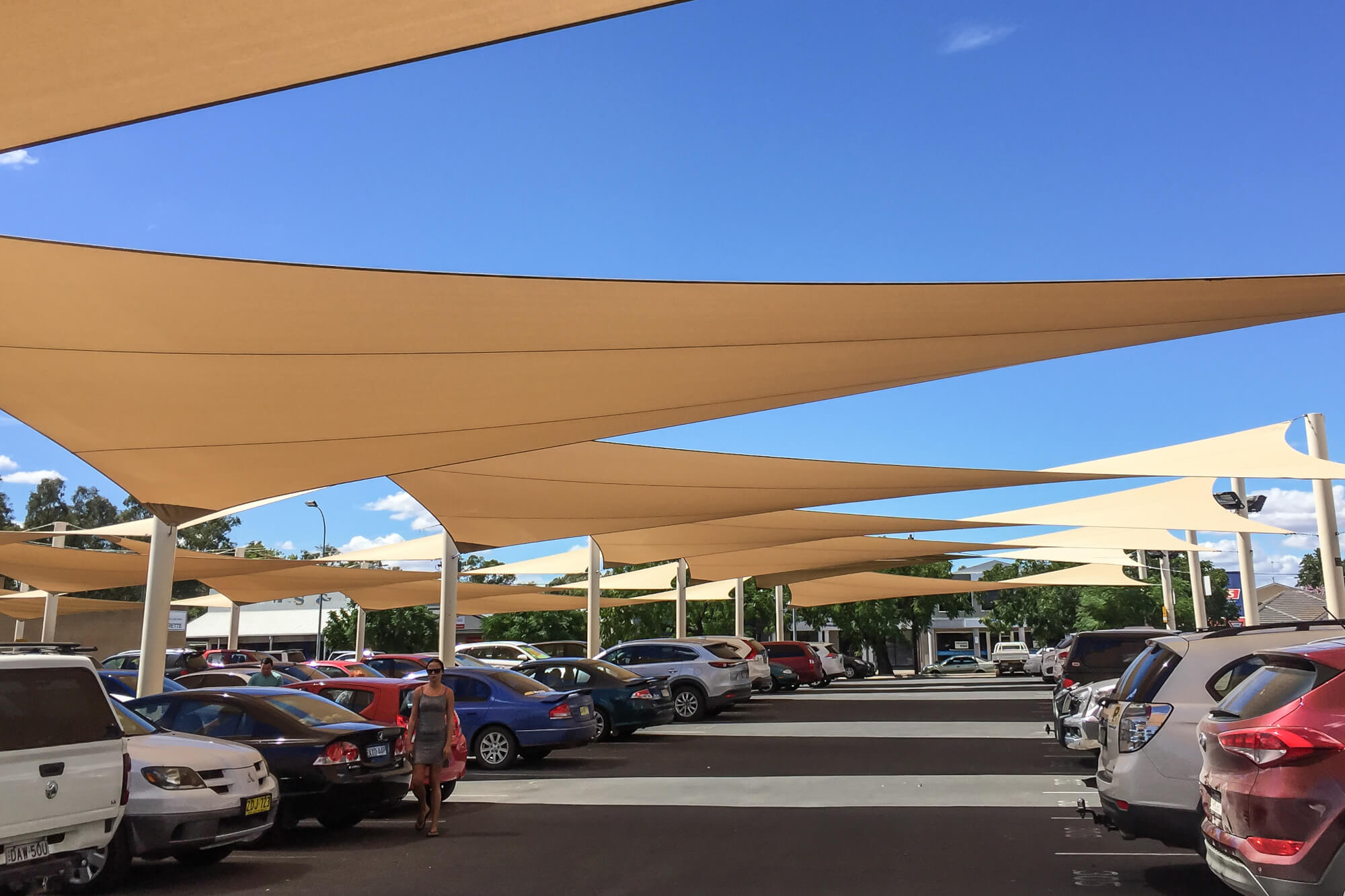Napvitorla játszótér árnyékolás 7 Nagy méretű parkoló árnyékolása bézs napvitorlákkal, személyautók védelmére
