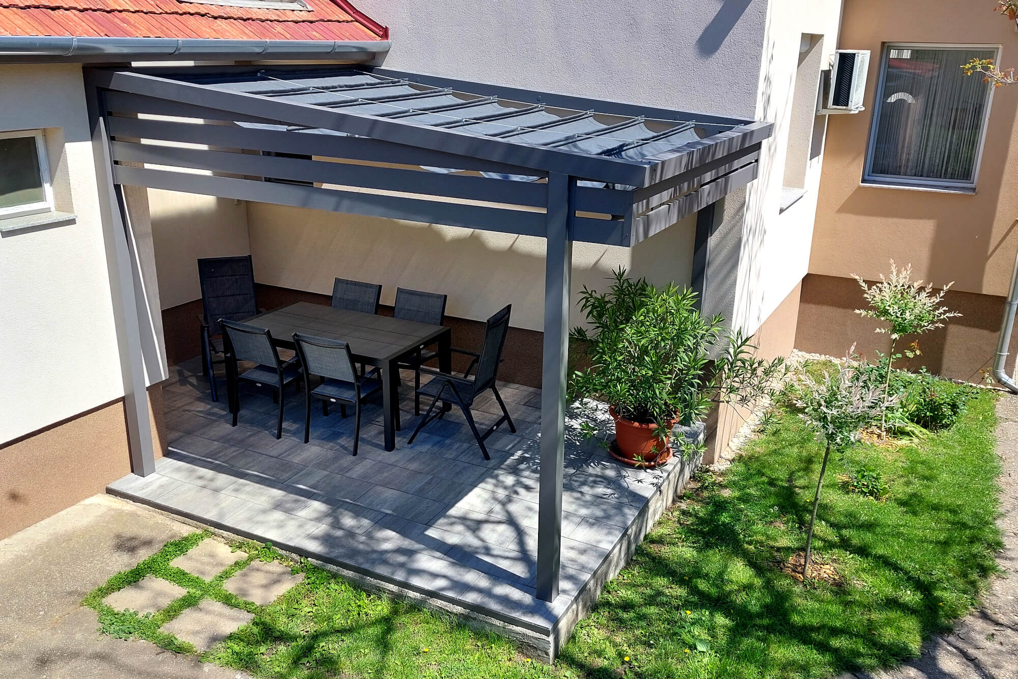 Napvitorla terasz 3 Modern pergola rendszer egy családi ház terasza fölött, kerti bútorokkal berendezve